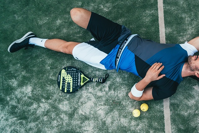 テニスコートで寝そべる男性